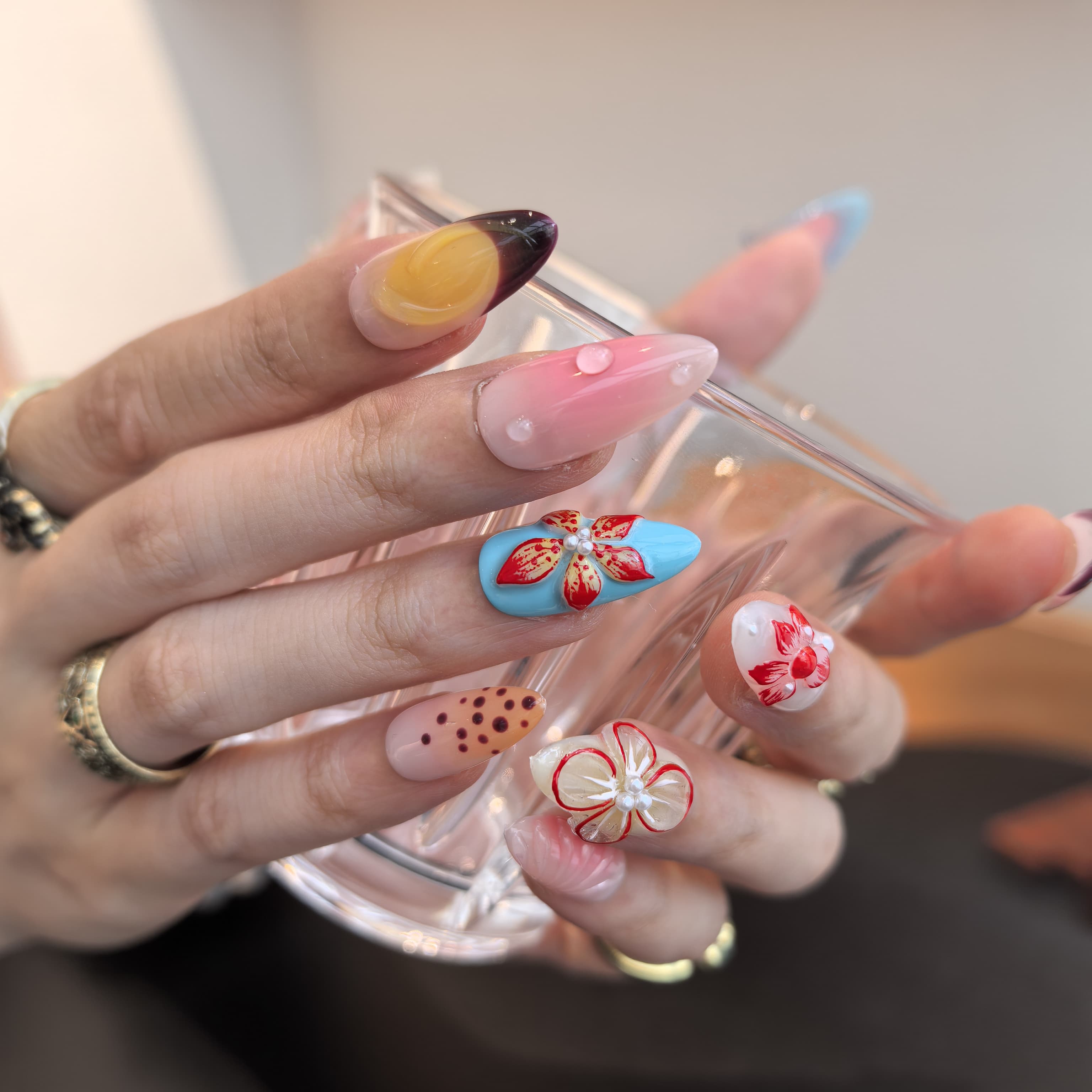 Blush Bloom press-on nails close-up – pearl embellishments and polka dot details on pastel floral almond nails