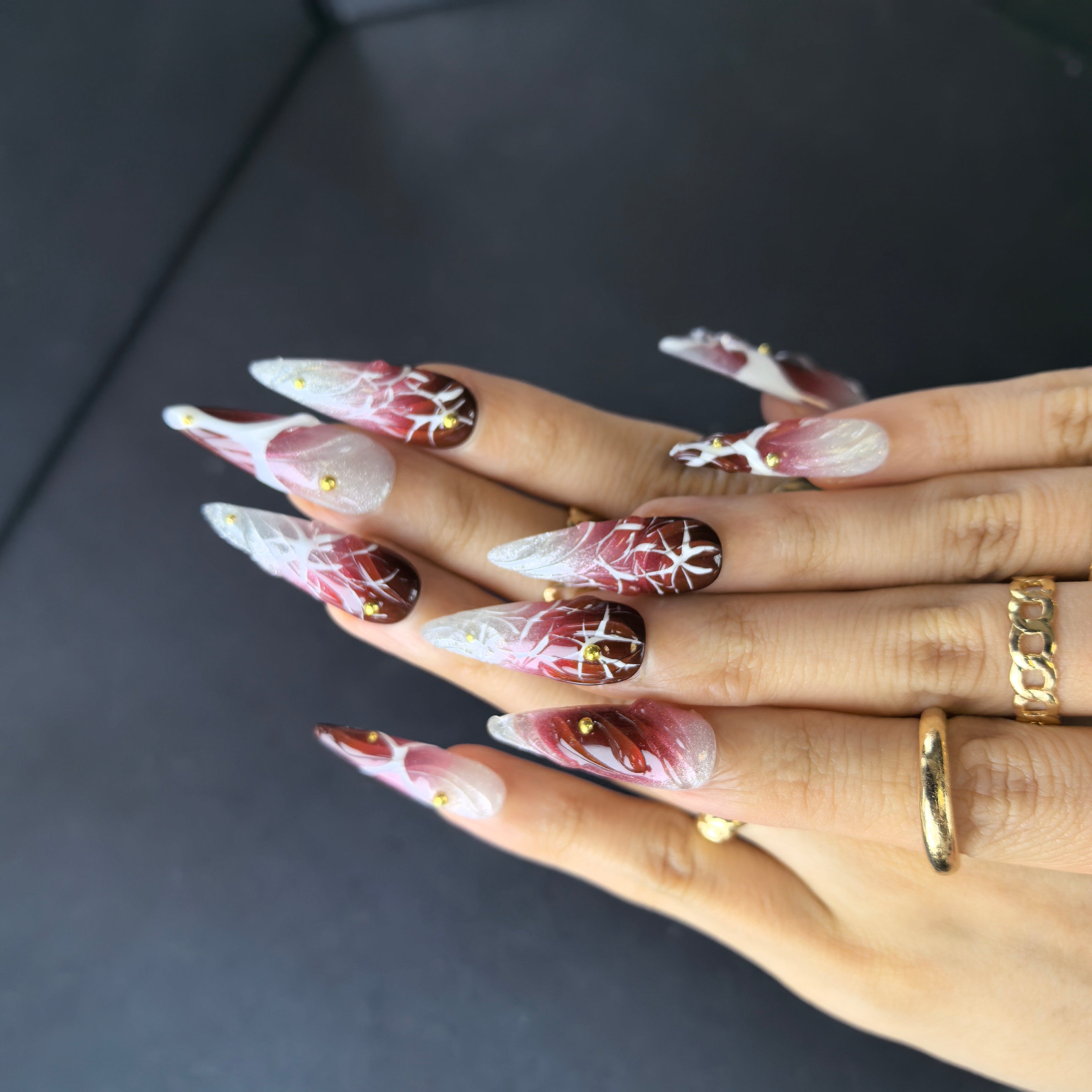 Close-up of Power Move press-on nails — white thorn pattern 3D red rose petal gold bead stud nail art by Poorguyshop