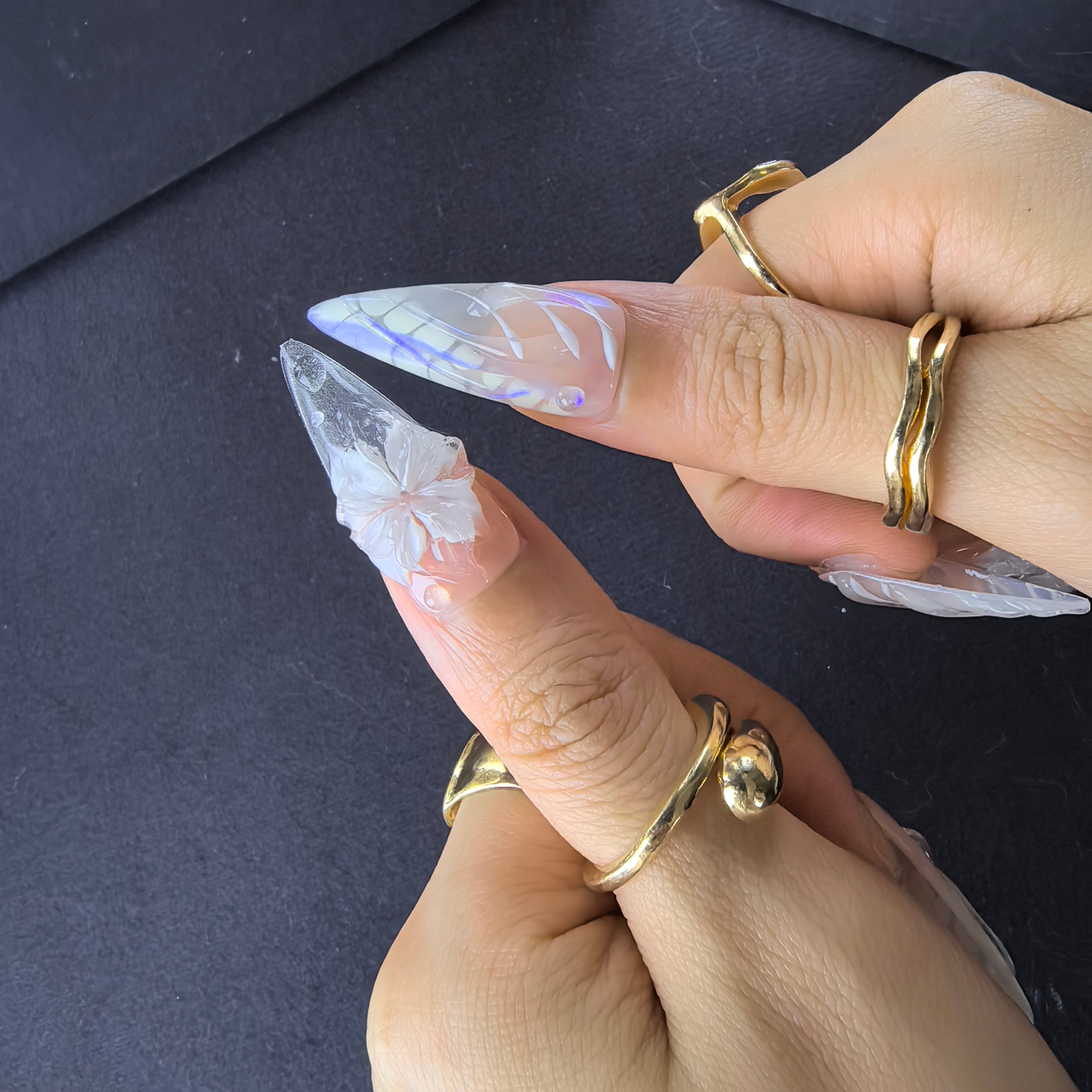 Mermaid Vein stiletto nails close-up – clear crystal accents and 3D white florals on blush to clear iridescent ombré