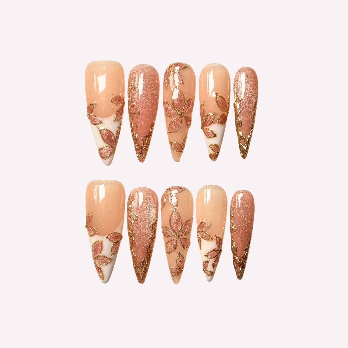PoorGuyShop Blush Petal handmade stiletto press-on nails – soft peachy base with gold-outlined floral patterns and shimmer accents, 25–30mm