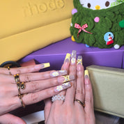 Southern Belle press-on nails close-up – delicate 3D yellow flower motifs and pearl accents on French tip squoval nails