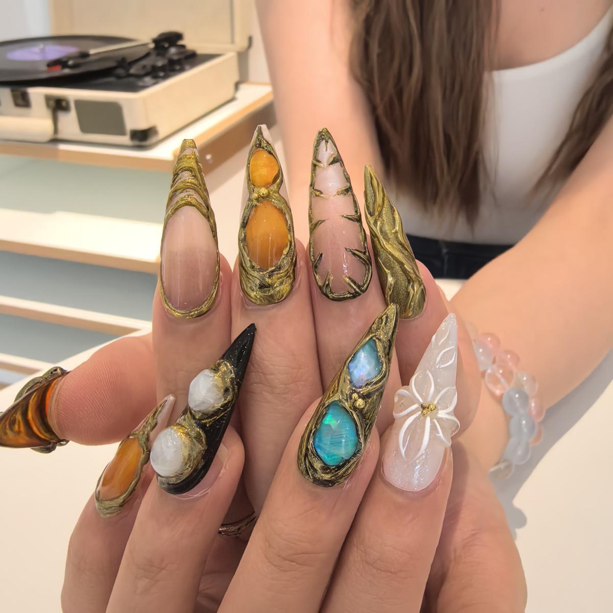 Woman wearing Castle handmade press-on nails — dark fantasy grey gold nail art coffin stiletto by Poorguyshop