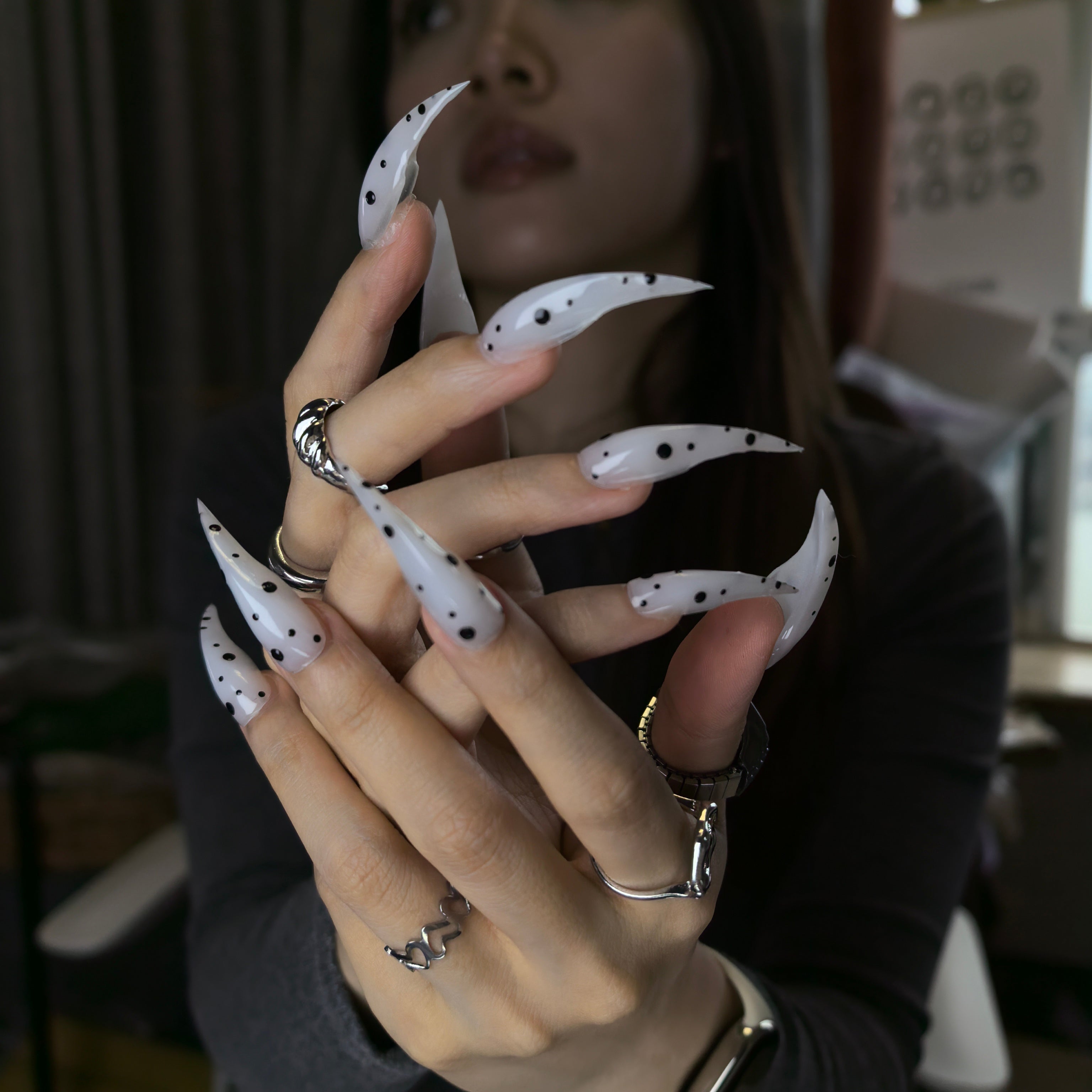 Woman wearing Cat Claw #9 handmade press-on nails — milky white black polka dot minimalist Y2K nail art by Poorguyshop
