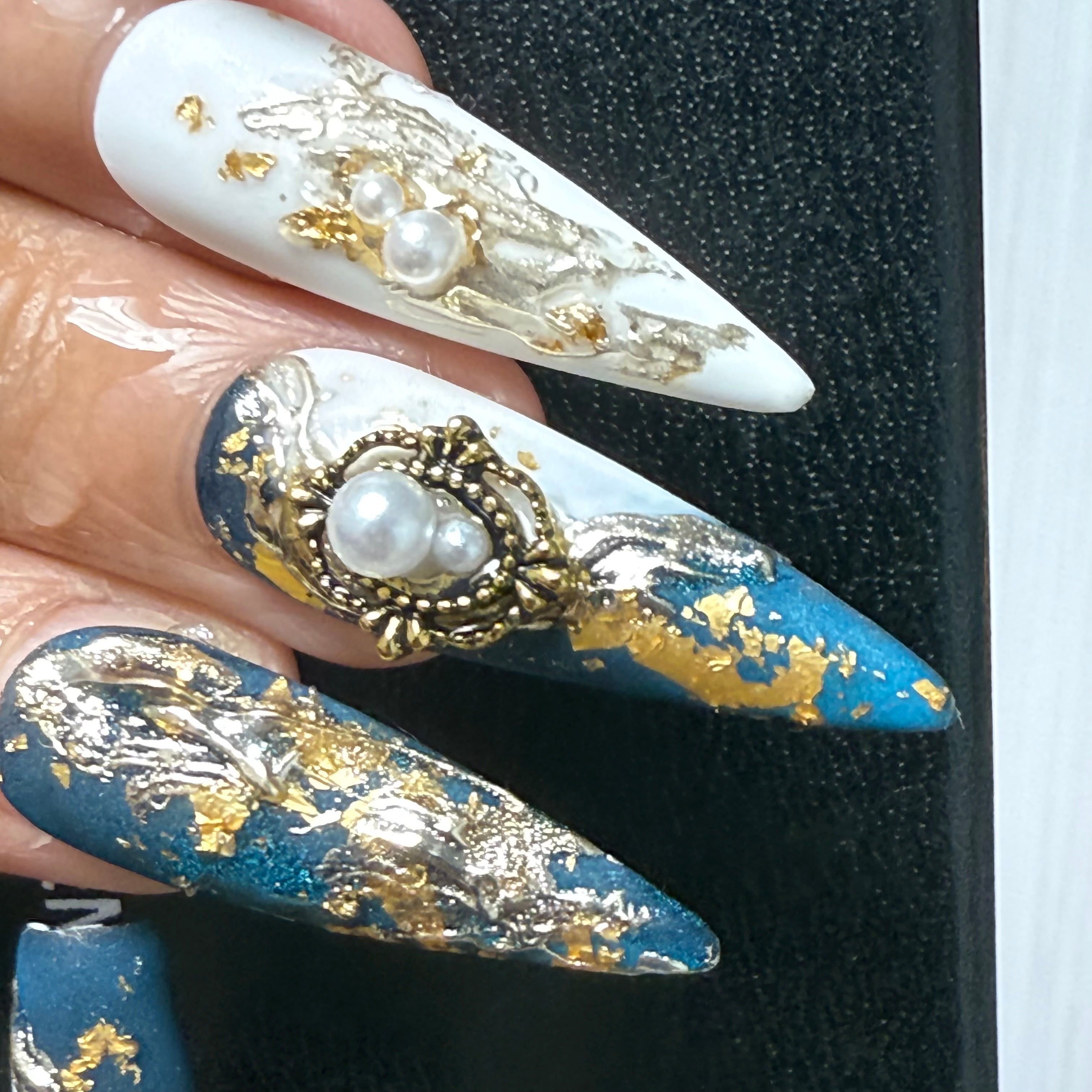 Woman wearing Gilded Cosmos handmade press-on nails — black gold galaxy nail art coffin stiletto by Poorguyshop