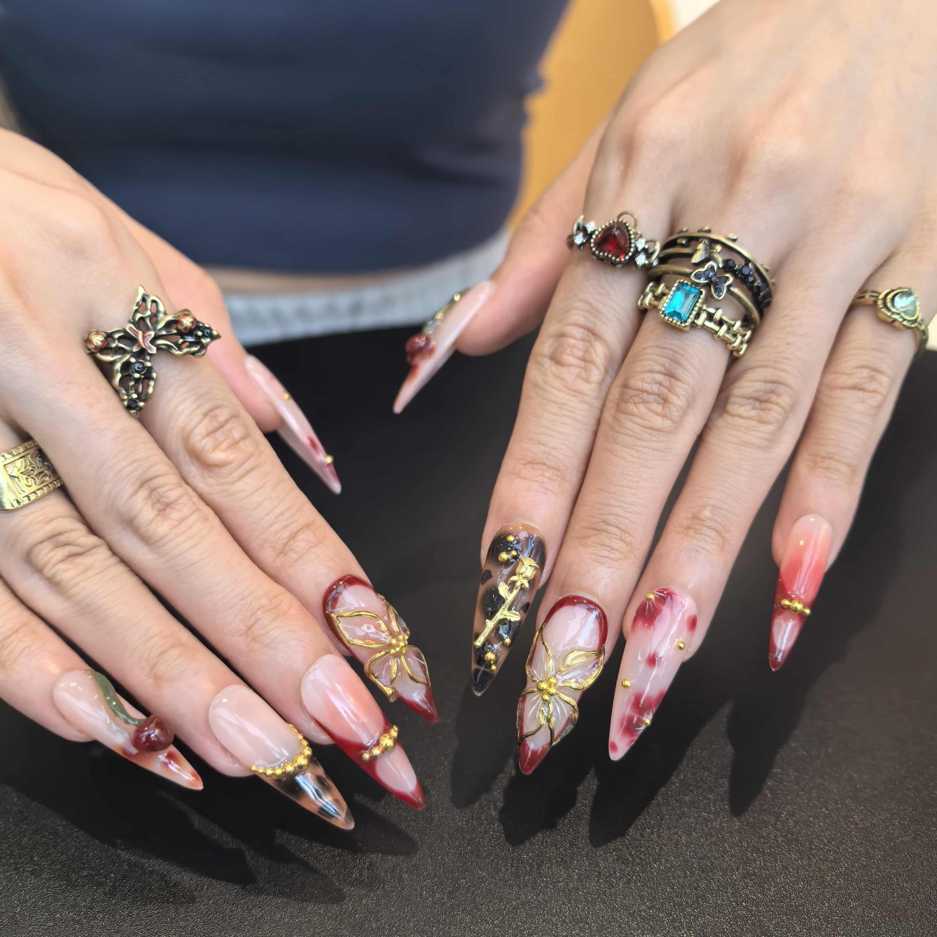 Woman wearing Lost Cherry handmade press-on nails — cherry blossom floral nail art coffin stiletto by Poorguyshop