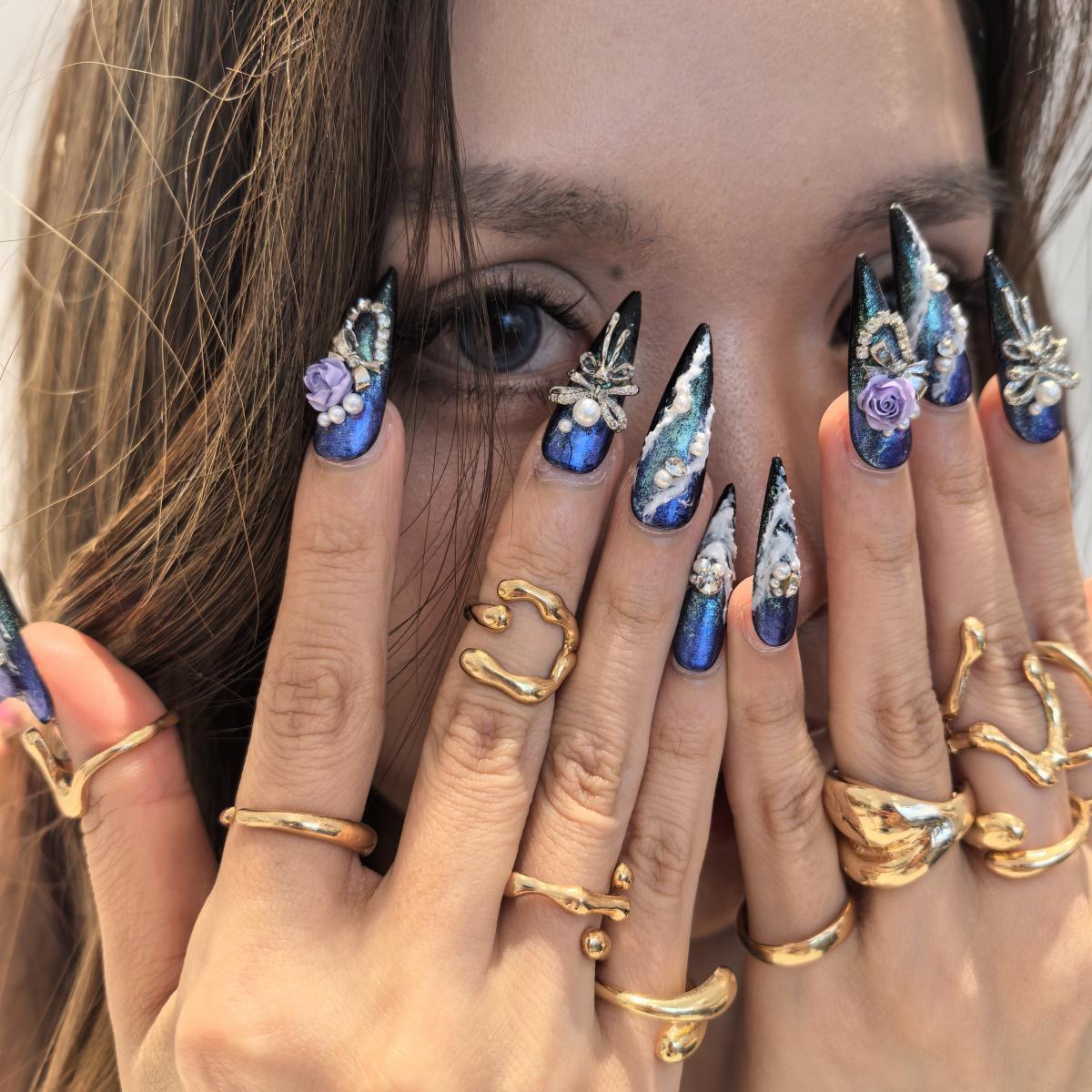 Woman wearing MGM handmade press-on nails — deep blue galaxy purple rose pearl rhinestone nail art coffin stiletto by Poorguyshop