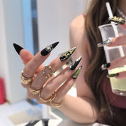 Woman wearing Nightmoss handmade press-on nails — black gold silver pearl butterfly bow nail art coffin stiletto by Poorguyshop
