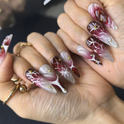 Woman wearing Power Move handmade press-on nails — burgundy silver thorn rose nail art stiletto by Poorguyshop