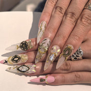 Woman wearing Skater Girl handmade press-on nails — gold gem bow crystal nail art coffin stiletto by Poorguyshop