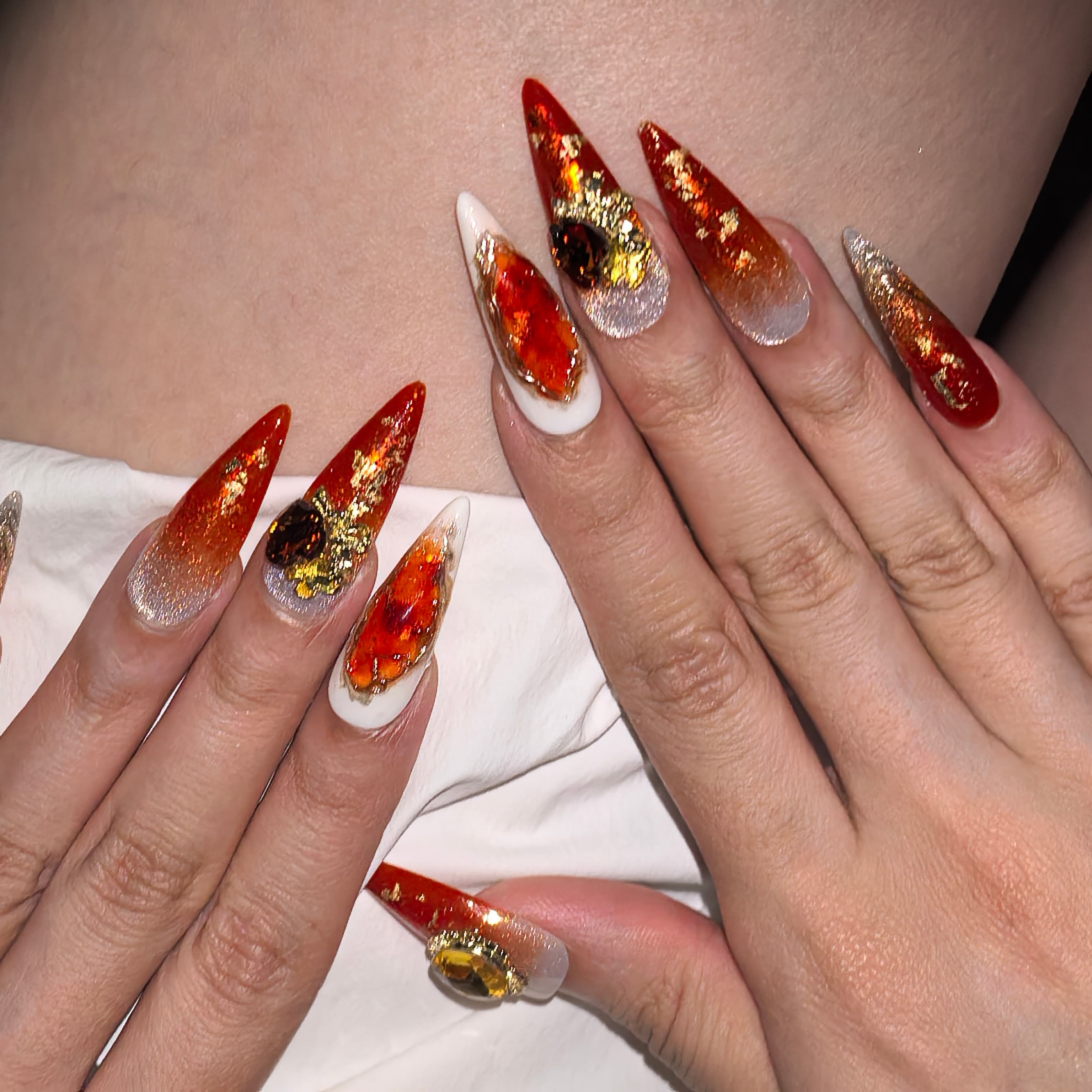 Woman wearing Twilight Ember handmade press-on nails — ruby red gold gradient citrine gem foil nail art coffin stiletto by Poorguyshop